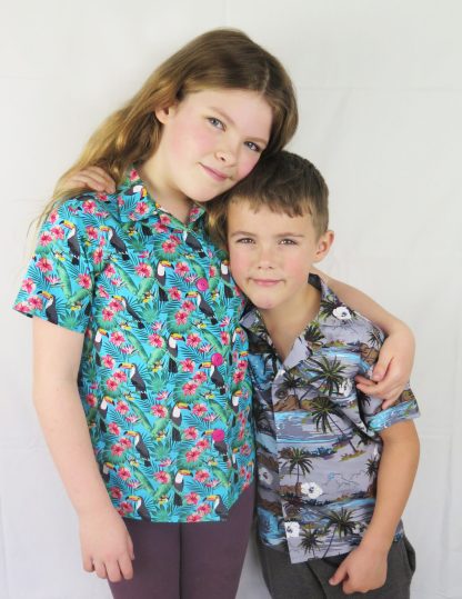 Children wearing the Children's Hawaiian Shirt sewing pattern from Ruth Maddock Makes on The Fold Line. A shirt pattern made in cotton poplin fabrics, featuring a soft collar, front button closure, external seams and short sleeves.