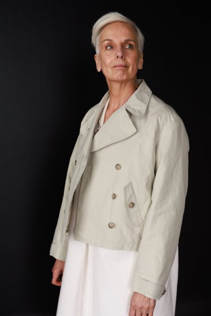 Woman wearing the Denham Jacket sewing pattern from Merchant & Mills on The Fold Line. A jacket pattern made in dry oilskin, oilskin, linen, denim, wool, corduroy, cotton twills or canvas fabrics, featuring two angled flap pockets, double breasted, button tab collar closure, and full length sleeve with adjustable button cuff tab.