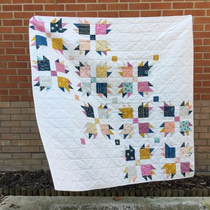 Image showing the paw Tracks Quilt sewing pattern from Lou Orth Designs on The Fold Line. A quilt pattern made in quilting cotton fabrics, featuring a bold and modern take on the classic bear paw quilt block.
