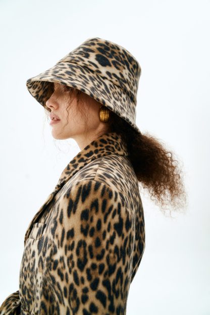 Woman wearing the Tory Hat sewing pattern from Vikisews on The Fold Line. A hat pattern made in faux fur, outerwear fabrics, denim, or faux leather fabrics, featuring a wide slanted brim and double-sided.