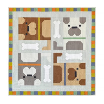 Photo showing the Dog Pile Quilt sewing pattern from Pen and Paper Patterns on The Fold Line. A quilt pattern made in quilting cotton fabrics, featuring four dogs and bones on a grey background with multicoloured squares along the quilt’s edges.