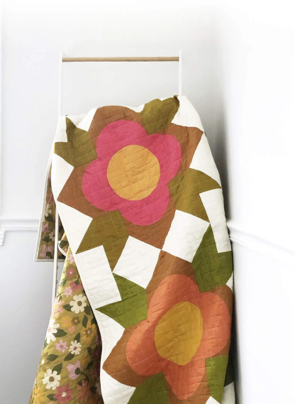 Photo showing the Flower Shop Quilt sewing pattern from Modern Handcraft on The Fold Line. A quilt pattern made in quilting cotton fabrics, featuring a big block pattern composed of three different block styles: square, triangle and quarter circle shapes.