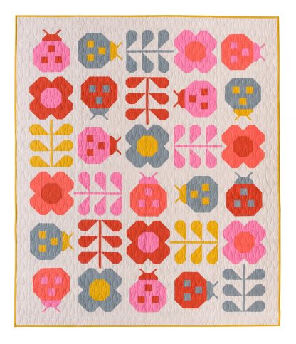 Photo showing the Hello Spring Quilt sewing pattern from Pen and Paper Patterns on The Fold Line. A quilt pattern made in quilting cotton fabrics, featuring ladybugs and flowers in pink, red, blue and yellow colours on a cream background.
