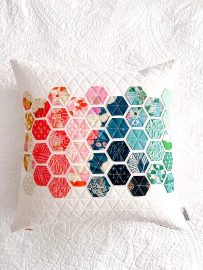 Photo showing the Hexie Pillow sewing pattern from Modern Handcraft on The Fold Line. A cushion pattern made in quilting cotton fabrics, featuring the modern hexie design which is a faster version of traditional hexagonal English paper piecing.