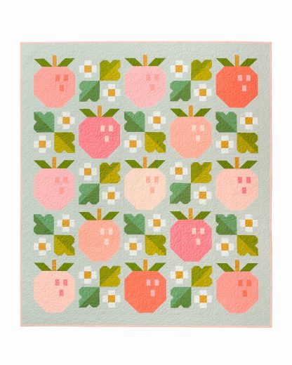 Photo showing the Pineberry Quilt sewing pattern from Pen and Paper Patterns on The Fold Line. A quilt pattern made in quilting cotton fabrics, featuring wineberries in pink and peach colours with a background of leaves and daises.