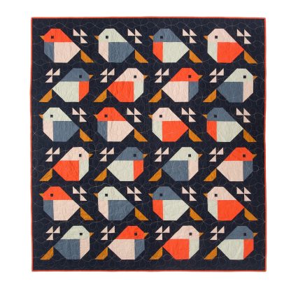Photo showing the Sparrow Quilt sewing pattern from Pen and Paper Patterns on The Fold Line. A quilt pattern made in quilting cotton fabrics, featuring multicoloured robins on a navy background using a blocked based design.