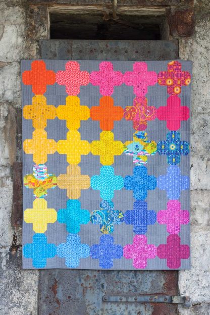 Photo showing the Ventana Quilt sewing pattern from Alison Glass on The Fold Line. A quilt pattern made in quilting cotton fabrics, featuring a design of crosses created by overlaying oblong shapes.