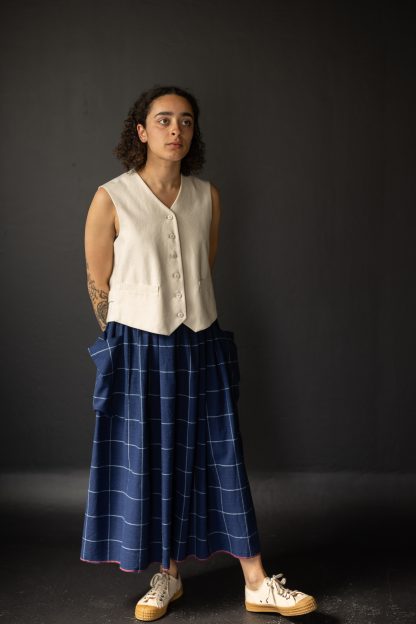 Woman wearing the Mathilde Skirt sewing pattern from Merchant & Mills on The Fold Line. A skirt pattern made in linen, brushed cotton, cotton lawn, cotton poplin, tencel, Indian handlooms, lightweight baby cord or cotton double gauze fabrics, featuring a deep elasticated waistband, patch pockets, midi length and relaxed fit.