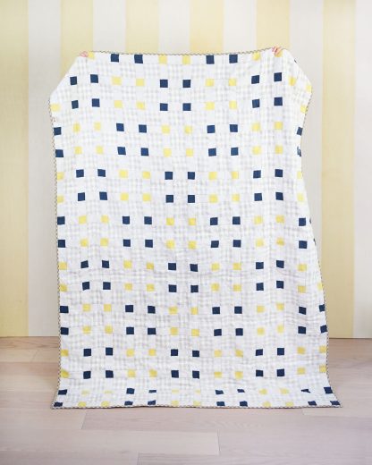 Photo showing the Picnic Square Quilt sewing pattern from Matchy Matchy on The Fold Line. A quilt pattern made in quilting cotton fabrics, featuring squares and rectangles, using the chain piecing method, use solid, prints or scrap collection fabrics.