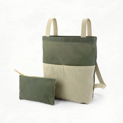 Photo showing the Belmont Pack and Pouch sewing pattern from Klum House on The Fold Line. A backpack and pouch pattern made in canvas, waxed canvas, or denim fabrics, featuring a bag that converts from tote to backpack and can be stored inside the zipper pouch. With convertible fabric straps, two-compartment exterior pocket, French seams, and boxed corners.