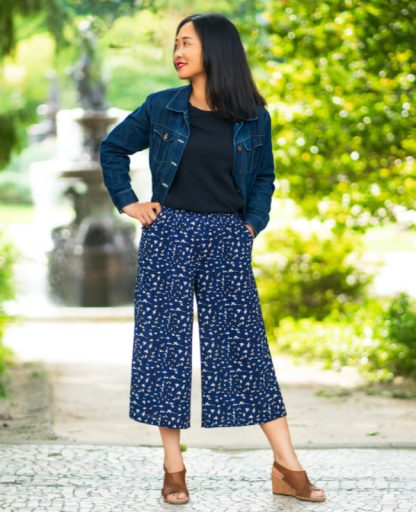 Woman wearing the Icaria Pants sewing pattern from Itch to Stitch on The Fold Line. A trouser pattern made in crepe, viscose/rayon twill and Tencel twill fabrics, featuring wide legs, ¾ length, relaxed fit, elasticated waist, and front slanted pockets.