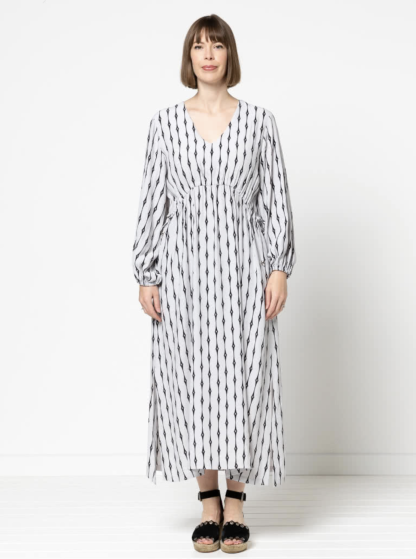 Woman wearing the Naomi Woven Dress sewing pattern from Style Arc on The Fold Line. A dress pattern made in rayon, crepe or silk fabrics, featuring a slip-on style, V-neck, angled waist seam with drawstring, 7/8-length sleeves with elasticated cuffs, side hem splits and midi length.