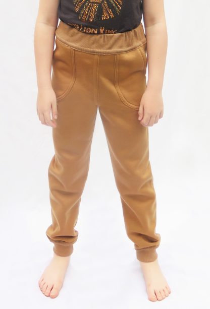 Child wearing the Children's Sweatpants sewing pattern from Ruth Maddock Makes on The Fold Line. A joggers pattern made in medium to heavy weight jersey fabrics, featuring seams worked on the outside, patch pockets, elasticated waistband and ankle cuffs.