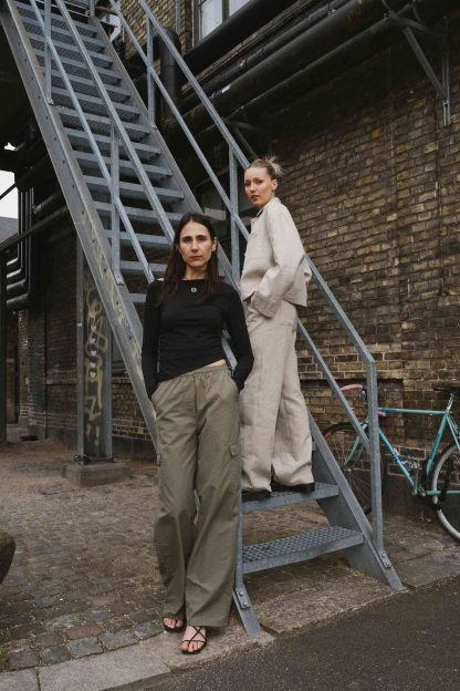 Women wearing the Versa Pants sewing pattern from Puff and Pencil on The Fold Line. A trousers pattern made in cotton twill, linen and taslan fabrics, featuring an adjustable elastic waist cord, front, back and side pockets, relaxed fit, wide straight legs and full length.