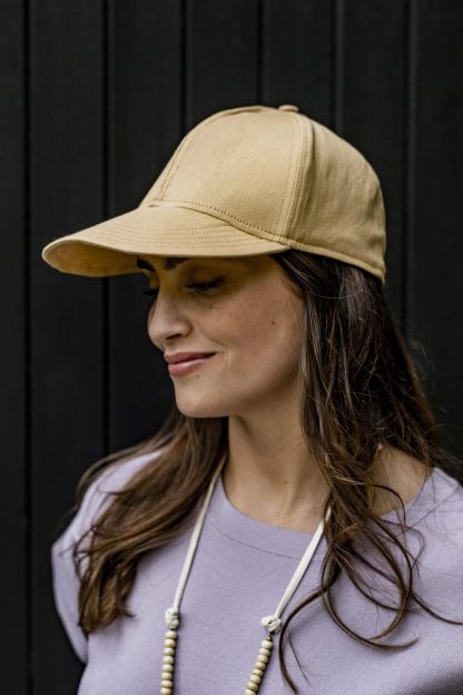 Woman wearing the Minu Cap sewing pattern from Fibre Mood on The Fold Line. A cap pattern made in denim, corduroy or heavyweight cotton fabrics, featuring a front peak, adjustable back strap and 5 panels.