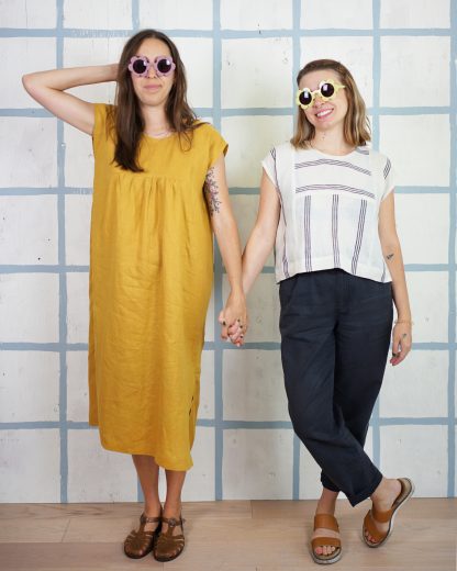 Women wearing the Skipper Top and Dress sewing pattern from Matchy Matchy on The Fold Line. A dress and top pattern made in light to medium weight woven fabrics, featuring a relaxed, boxy fit, scoop neckline, dropped shoulders, back yoke with gathers. Top is slightly cropped. Dress has in-seam pockets and side slits.