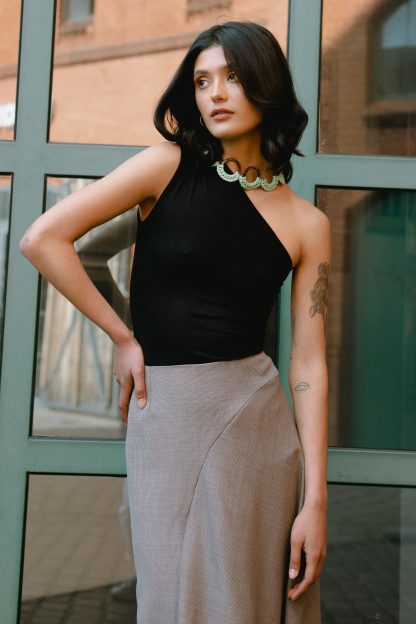 Woman wearing the Cara Top sewing pattern from JULIANA MARTEJEVS on The Fold Line. A knit top pattern made in cotton jersey fabrics, featuring an asymmetric style with cold shoulder, close fitting and sleeveless.