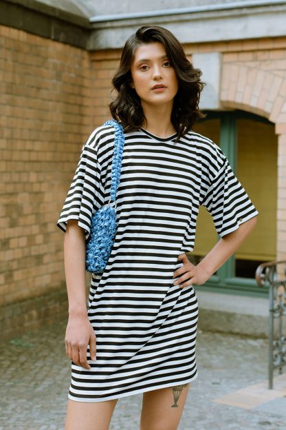 Woman wearing the T-shirt Dress sewing pattern from JULIANA MARTEJEVS on The Fold Line. A T-shirt dress pattern made in cotton jersey fabrics, featuring a relaxed fit, round neck, mini length and elbow length wide sleeves.