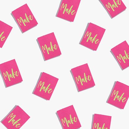 Photo showing 'Make’ Labels from Kylie & The Machine on The Fold Line. A washable, durable, and non-scratchy label. Included are, 6 woven labels with lime green lettering on a dark pink background. They are all ready to be sewn into your handmade clothes.