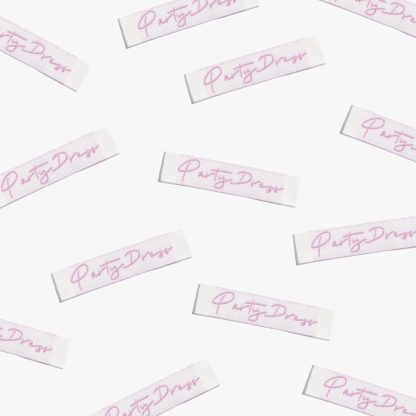 Photo showing 'Party Dress’ Labels from Kylie & The Machine on The Fold Line. A washable, durable, and non-scratchy label. Included are, 6 woven labels with pink lettering on a white background. They are all ready to be sewn into your handmade clothes.