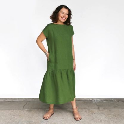 Woman wearing the Mattea Dress sewing pattern from Tessuti Fabrics on The Fold Line. A dress pattern made in linen, cotton, viscose or silk fabrics, featuring a semi-fitted bodice, boat neckline, dropped shoulders, sleeveless, calf-length, dropped waist, in-seam pockets and gathered skirt from mid-thigh.