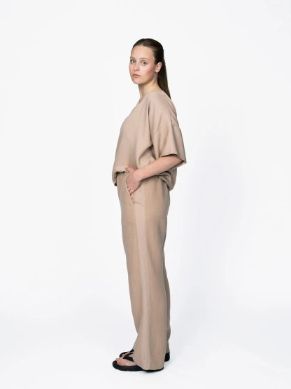 Woman wearing the Women's Pull-on Trousers sewing pattern from The Assembly Line on The Fold Line. A trouser pattern made in cotton, linen, viscose, wool, lightweight twill fabrics, featuring an elastic waist, wide legs, slant pockets and side stripes.