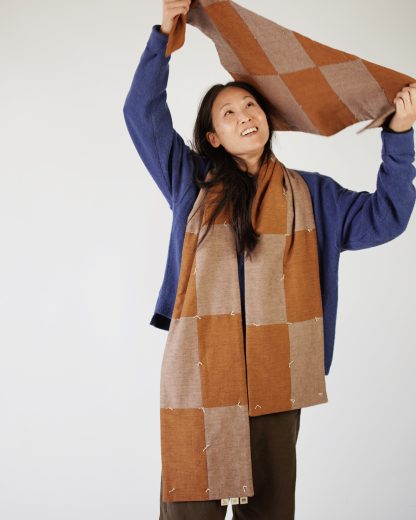 Woman wearing the Butter Quilt Scarf sewing pattern from Matchy Matchy on The Fold Line. A scarf pattern made in quilting cottons or linen fabrics, featuring a long length, double thickness and rectangular pattern shapes.