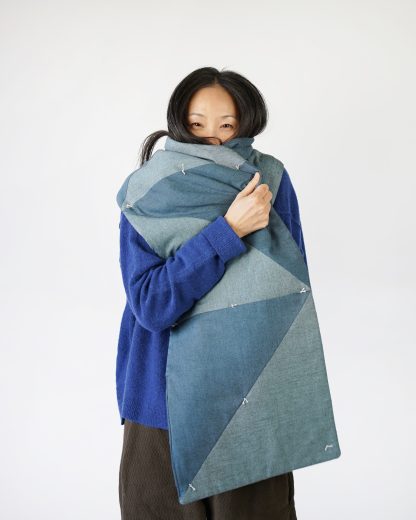 Woman wearing the Sugar Quilt Scarf sewing pattern from Matchy Matchy on The Fold Line. A scarf pattern made in quilting cottons or linen fabrics, featuring a long length, double thickness and triangular pattern shapes.