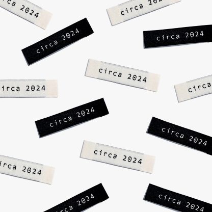 Photo showing 'Circa 2024' Labels from Kylie & The Machine on The Fold Line. A washable, durable, and non-scratchy label. Included are 6 woven labels: 3 x black polyester labels with cream text and 3 x off-white polyester labels with black text. They are all ready to be sewn into your handmade clothes.
