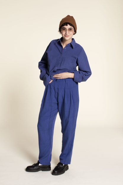Woman wearing the Cocoon Pants sewing pattern from Wardrobe by Me on The Fold Line. A trouser pattern made in cotton twill, denim or corduroy fabrics, featuring a relaxed fit, tapered legs, contoured waistband, fly front zipper, deep front pleats, side pockets, and back welt pockets.