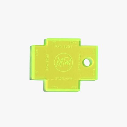 Photo showing the Label Gauge from Kylie & The Machine on The Fold Line. This fluorescent yellow acrylic gauge with laser etched measurements will help you to position your label perfectly with the four most common seam allowances.