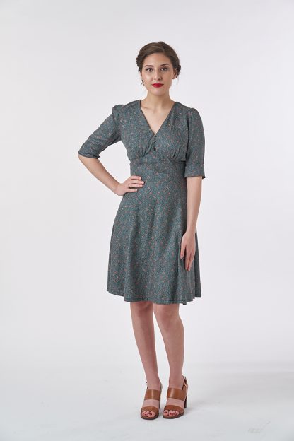 Woman wearing the 1940’s Tea Dress sewing pattern from Sew Over It on The Fold Line. A dress pattern made in crepe, rayon, satin or silk fabrics, featuring a gathered bust, panelled midriff and skirt, elbow length sleeves with cuffs, three decorative buttons down center front, knee length and V-neckline.