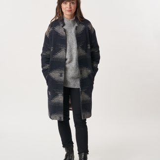 Woman wearing the Cocoon Coat sewing pattern from Sew Over It on The Fold Line. A coat pattern made in boucle, boiled wool, or melton wool fabrics, featuring a relaxed fit, fully lined, shaped collar stand, drop shoulder, full length sleeve and knee length.
