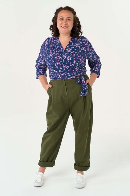 Woman wearing the Ella Blouse sewing pattern from Sew Over It on The Fold Line. A blouse pattern made in cotton lawn, rayon, viscose, or crepe fabric, featuring a wrap front that secures with ties and 3/4 length grown-on sleeves.