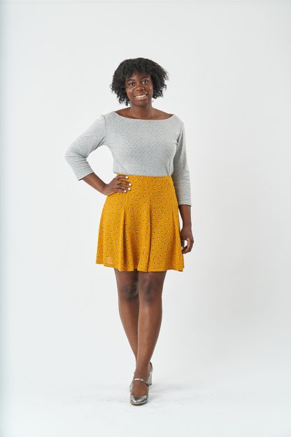 Woman wearing the Haxby Skirt sewing pattern from Sew Over It on The Fold Line. A skirt pattern made in rayon, viscose, viscose twill, or crepe fabric, featuring a high waist, waist facing, godet panels, invisible zip, and mini length.