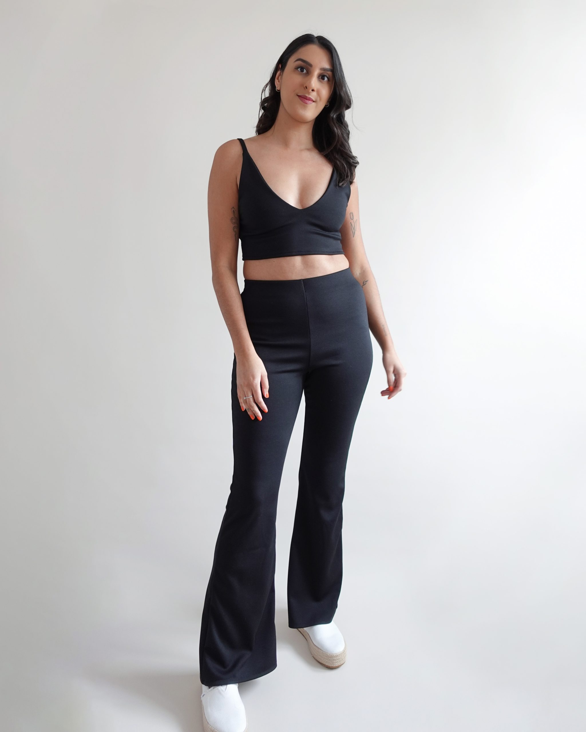 Woman wearing the Freya Flare Trouser sewing pattern from Tammy Handmade on The Fold Line. A trouser pattern made in jersey, ribbed knit, sweater knit, or ponte roma fabrics, featuring a high-waist, elasticated waistband, and flared leg.