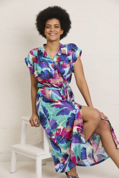Woman wearing the Ava Summer Dress sewing pattern from Atelier Jupe on The Fold Line. A dress pattern made in viscose, cotton, tencel, double gauze, or linen fabric, featuring a button placket, collar with stand, bodice gathers, folded cuffs, a belt, and midi length.
