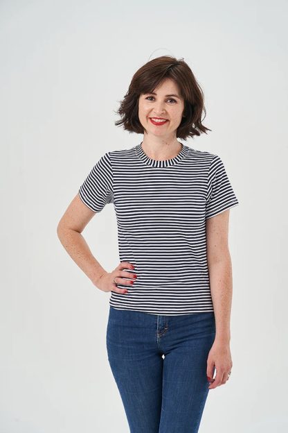 Woman wearing the Bilberry T-shirt sewing pattern from Sew Over It on The Fold Line. A T-shirt pattern made in knit fabrics such as cotton jersey or viscose jersey, featuring a slim fit, short set-in sleeves, and a classic high round neckline.