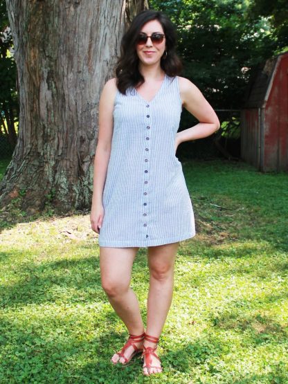 Woman wearing the Hana Dress sewing pattern from Pattern Scout on The Fold Line. A sleeveless dress pattern made in light to mid-weight woven fabrics, featuring a V-neck, button front closure, bust darts and above knee length hem.