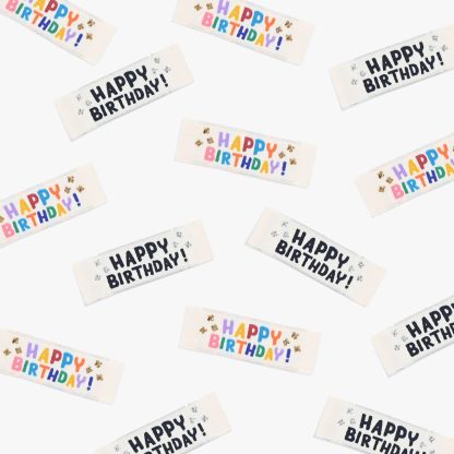 Photo of the ‘Happy Birthday!’ woven labels from Kylie & The Machine on The Fold Line. The pack includes 6 woven labels with bright coloured and metallic threads on a cream background, ready to be sewn into your handmade clothes.
