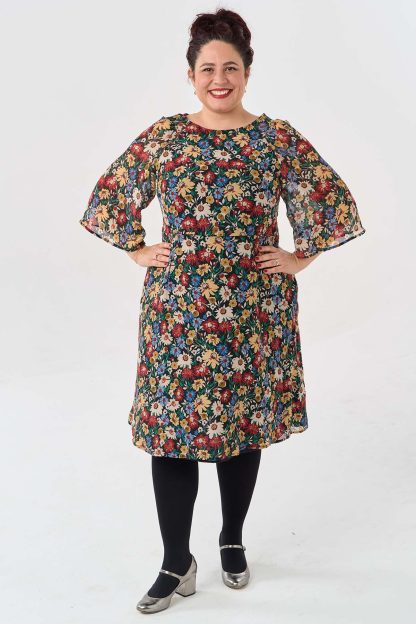 Woman wearing the Margot Dress sewing pattern from Sew Over It on The Fold Line. A dress pattern made in viscose, crepe, or chiffon fabric, featuring raglan 3/4 length bell sleeves, a lined bodice, French darts, an invisible side zip, and below the knee skirt.