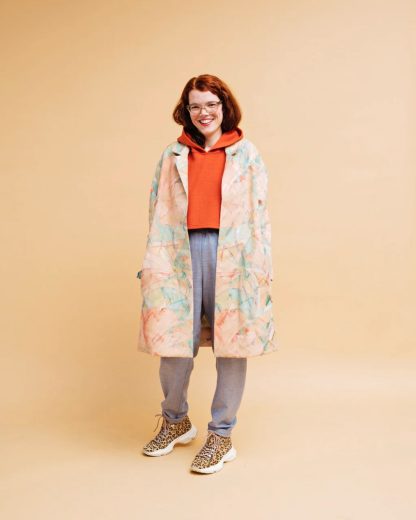 Woman wearing the Marte Coat sewing pattern from Melilot on The Fold Line. A coat pattern made in cotton, linen or wool fabrics, featuring an oversized fit, dropped shoulders, side seam pockets, and front button closure.