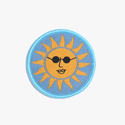 Photo of the ‘Sunglasses Sun’ iron-on patch from Kylie & The Machine on The Fold Line. A round patch with a yellow sun on a blue background ready to be attached to your handmade garment or bag.