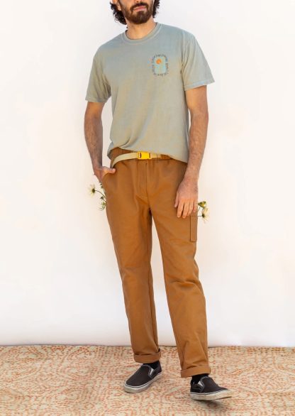 Man wearing the Men’s Rambler Pants sewing pattern from Friday Pattern Company on The Fold Line. A pull-on pants pattern made in denim, twill, or canvas fabric, featuring a relaxed fit, elastic waist with a built-in belt, faux fly, side and patch pockets, and slightly tapered legs.