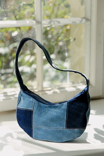 Photo of the Ava Bag sewing pattern from JULIANA MARTEJEVS on The Fold Line. A bag pattern made in denim or corduroy fabric, featuring an on-trend patchwork design, short shoulder strap, metal zipper, and inside pocket.