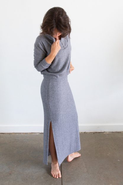 Woman wearing the Weaver Skirt sewing pattern from Allie Olson on The Fold Line. A skirt pattern made in knit fabric, featuring a fitted silhouette, hidden elastic waistband, double side slits, maxi length, and lining.