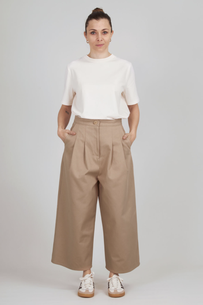 Woman wearing the Harmonie Trousers sewing pattern from I AM Patterns on The Fold Line. A trousers pattern made in crepe, Tencel, cotton or viscose twill, viscose, silk, lightweight denim, or linen fabric, featuring a high waist, fly front zipper, front pleats, Italian pockets, and back patch pockets.