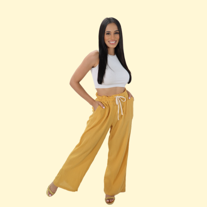 Woman wearing the Kathryn Pants sewing pattern from Sirena Patterns on The Fold Line. A pants pattern made in linen, cotton, cotton blends, chambray, or poplin fabric, featuring a relaxed fit, wide legs, diagonal side pockets, and an elastic waist with a drawstring cord.
